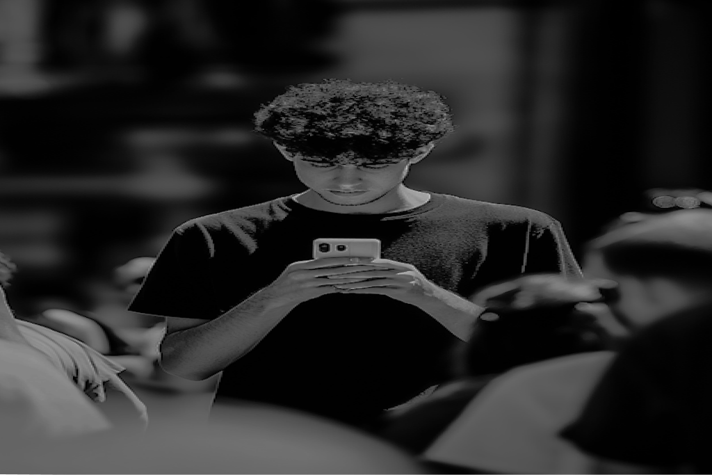 Jovem usando o celular no meio de uma multidão